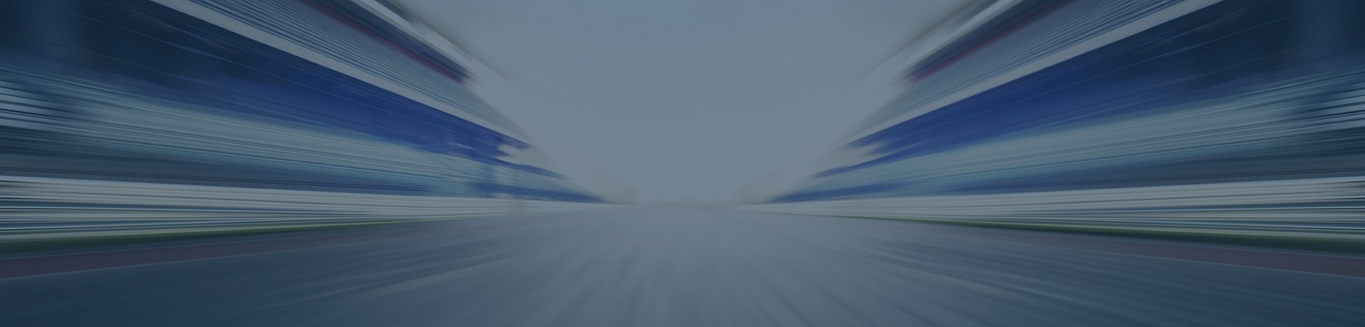 Unscharfes abstraktes Bild einer Straße zwischen Gebäuden, das ein Gefühl von schneller Bewegung und Geschwindigkeit vermittelt.